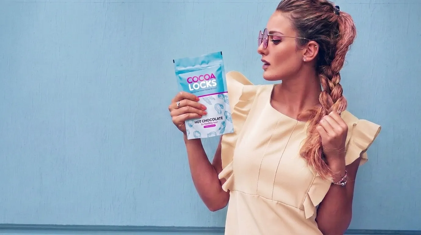 A Cocoa Locks customer holding the Hot Chocolate hair vitamin pouch